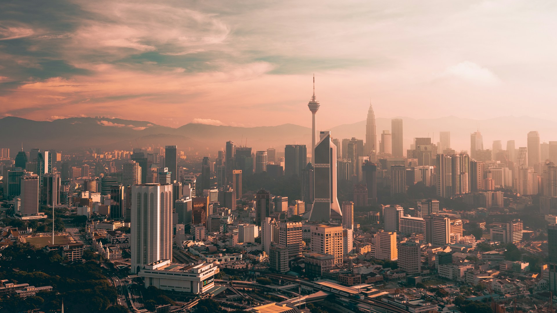 Kuala Lumpur skyline at golden hour with the KL Tower and Petronas Twin Towers